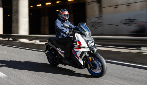 Motorcyclist Riding BMW Motorrad C 400 X Through Town