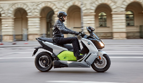 Motorcyclist Riding BMW Motorrad C Evolution Through Town