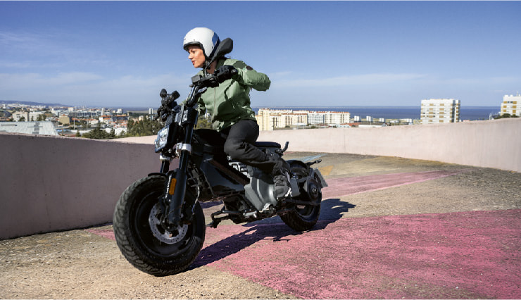 Motorcyclist Riding BMW Motorrad CE 02 Through Town