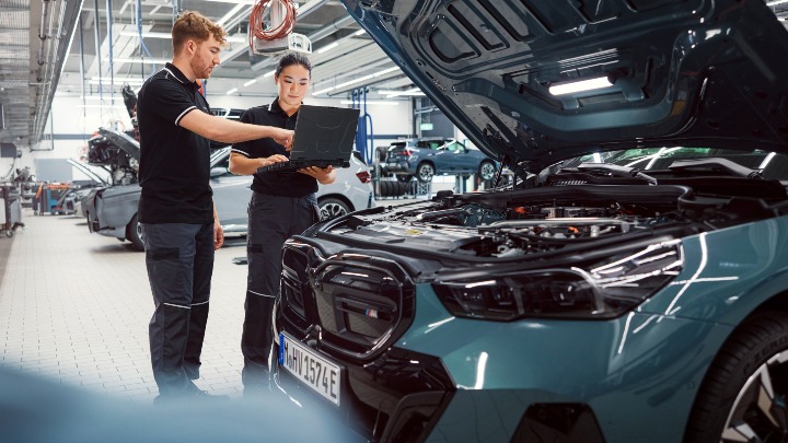 Two BMW Technicians Inspecting Open BMW Engine Bay