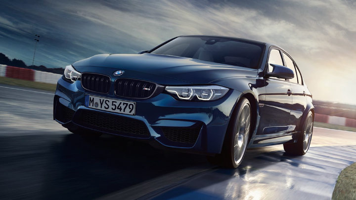 BMW M3 in blue driving on the road.