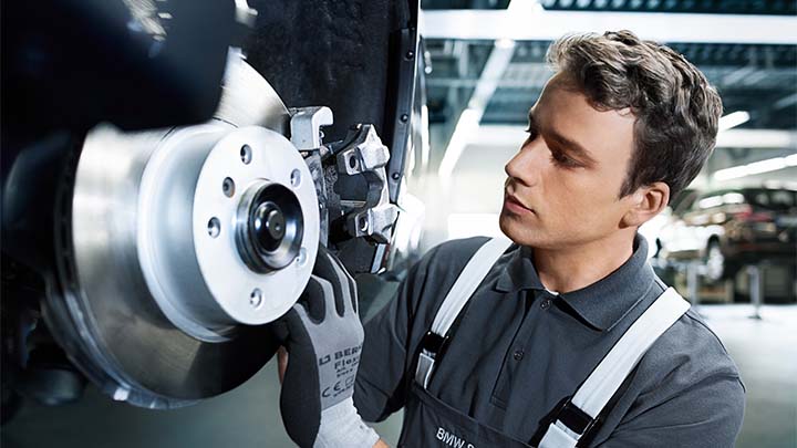 bmw technician inspecting brakes