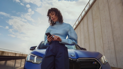 Woman standing in front of a blue BMW