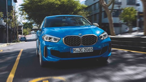 BMW 1 Series in blue driving on the road.