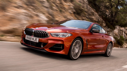 Orange BMW 8 Series Exterior Front Driving in Front of Rocky Terrain