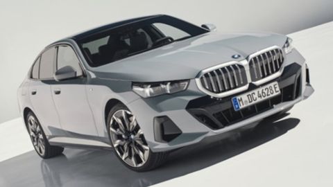 Silver BMW i5 parked in a white background