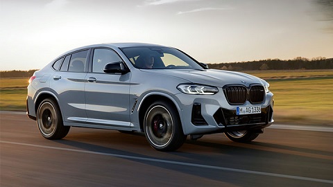 Silver BMW X4, driving in sunset