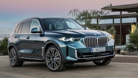 Blue BMW X5 parked in front of a modern looking house