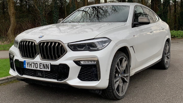 White BMW X6 M50d Exterior Front Static in Front of Trees