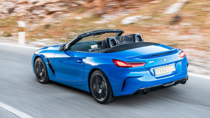Blue BMW Z4 Exterior Rear Driving on Road with Rocky Terrain in the Background