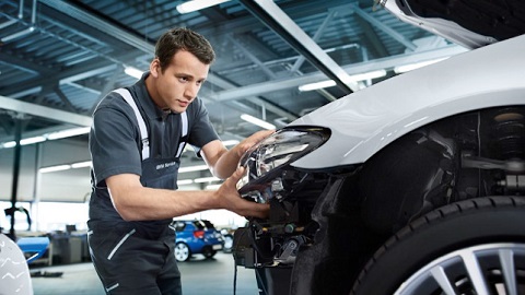 bmw technician changing headlight