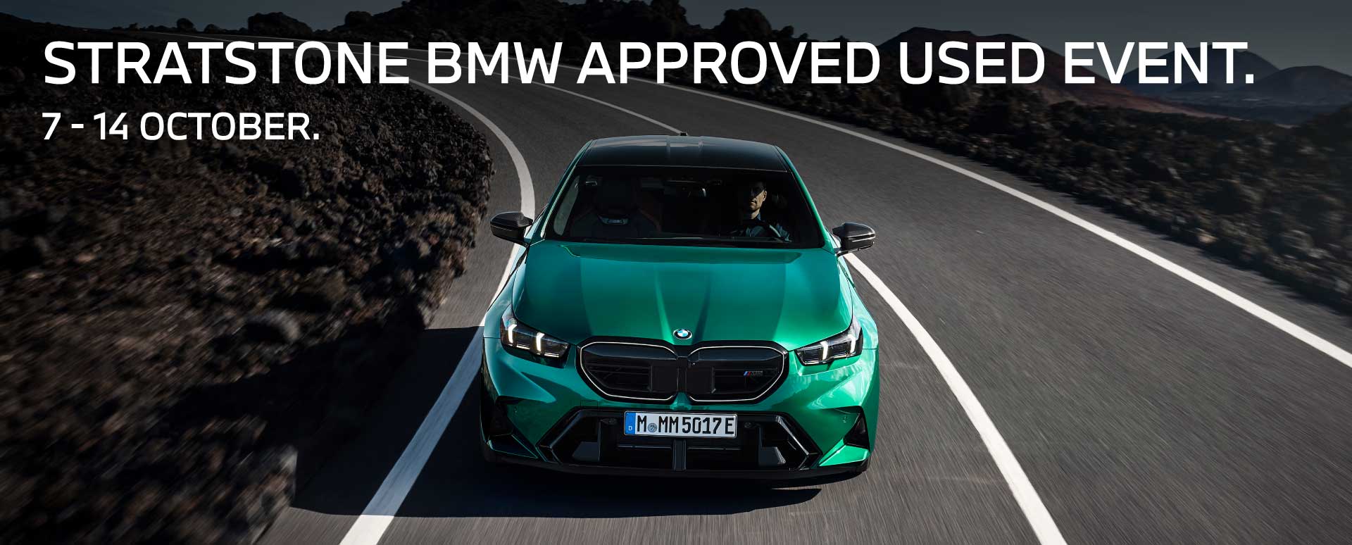 Metallic Green BMW Vehicle Driving Round Road Bend