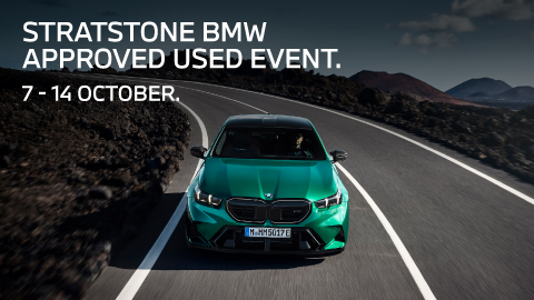 Metallic Green BMW Vehicle Driving Round Road Bend