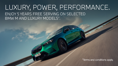 Green BMW M car travelling on the road. BMW promotion.