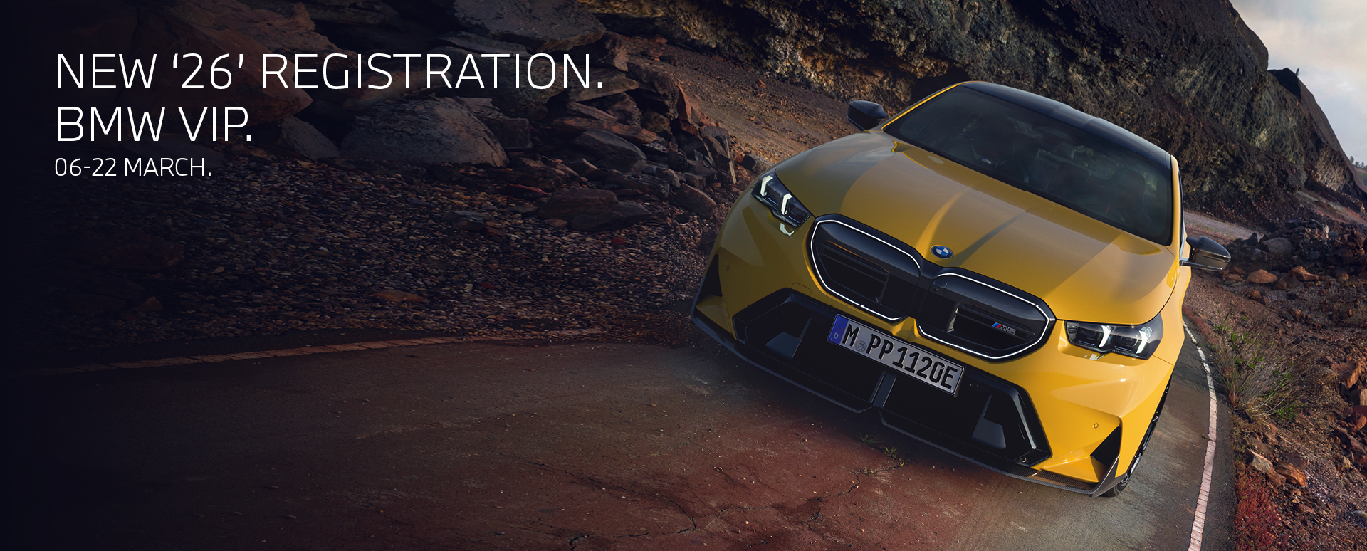 Front of yellow BMW car driving on a dirt road. Promotion text overlay.