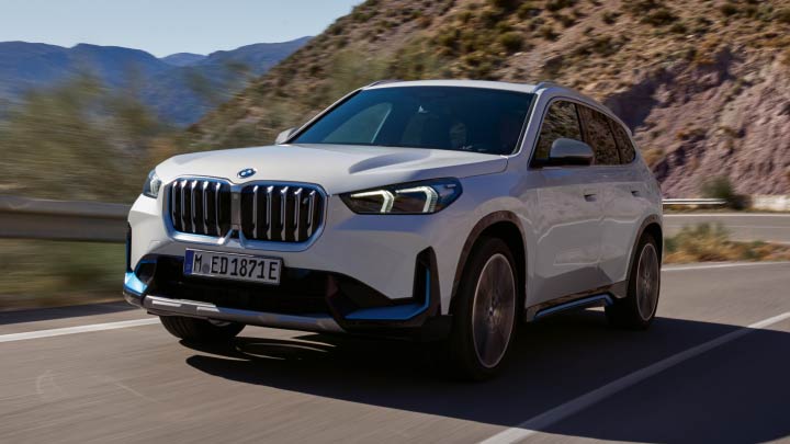 White BMW iX1 Driving On Mountain Road