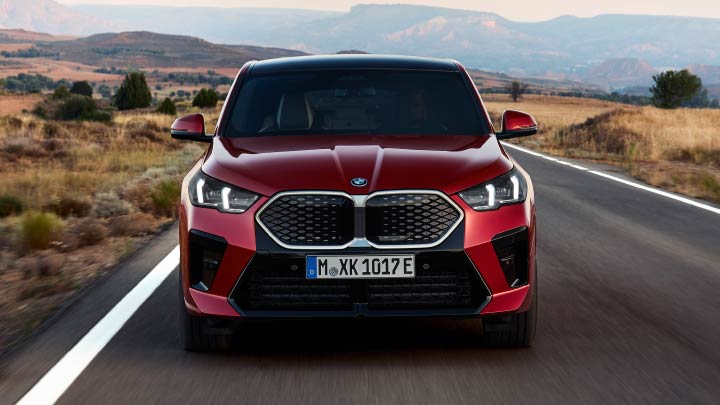 Front Shot of Red BMW iX2 Driving On Mountain Road
