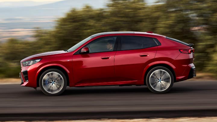 Side Shot of Red BMW iX2 Driving On Mountain Road