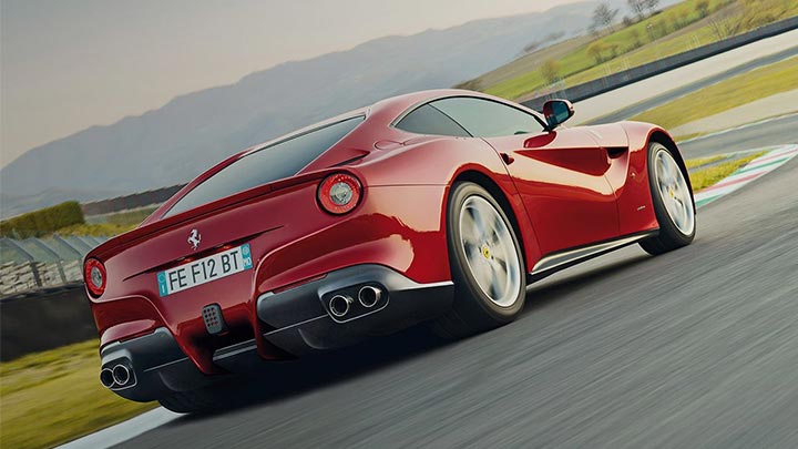 Rear quarter shot of a driving red Ferrari F12 Berlinetta