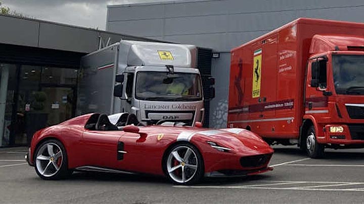 Red Ferrari parked outside a Stratstone Ferrari dealership