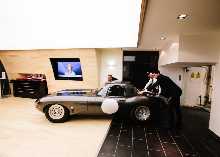 Staff pushing the Jaguar Lightweight E-Type in the basement.