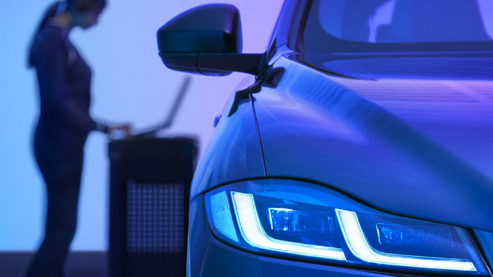 Woman charging a Jaguar vehicle.