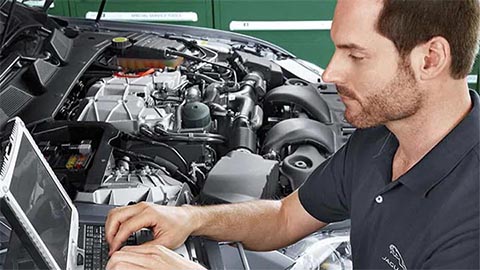 jaguar technician completing diagnostics on an engine