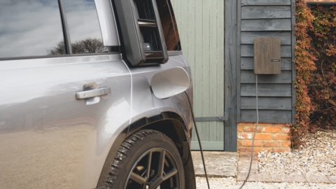 Land Rover Defender Charging Outside House