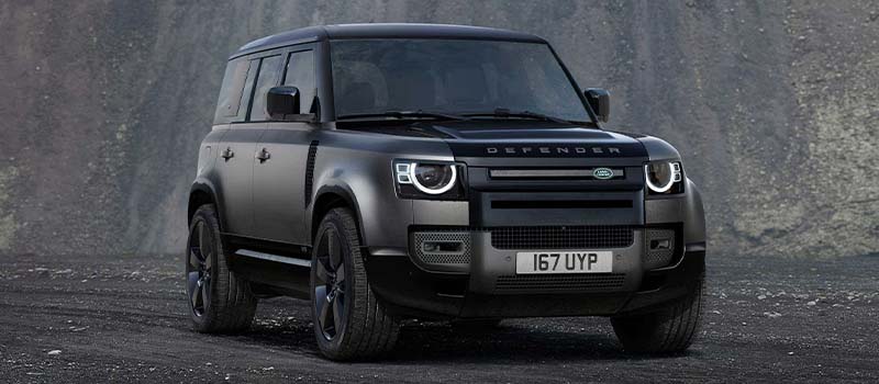 Grey and black Land Rover Defender 110 with AI generated mountain background