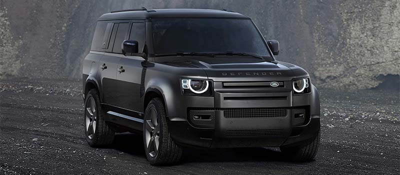 Grey and black Land Rover Defender 130 with AI generated mountain background