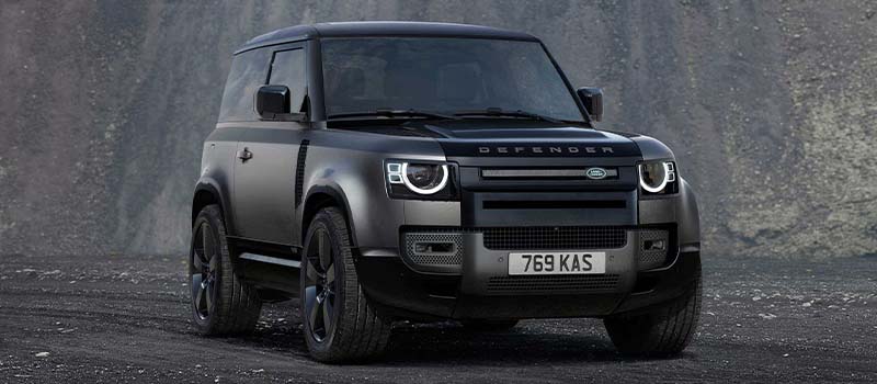 Grey and black Land Rover Defender 90 with AI generated mountain background