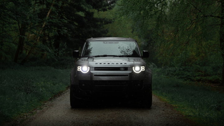 Land Rover Defender Parked in Forest Head On