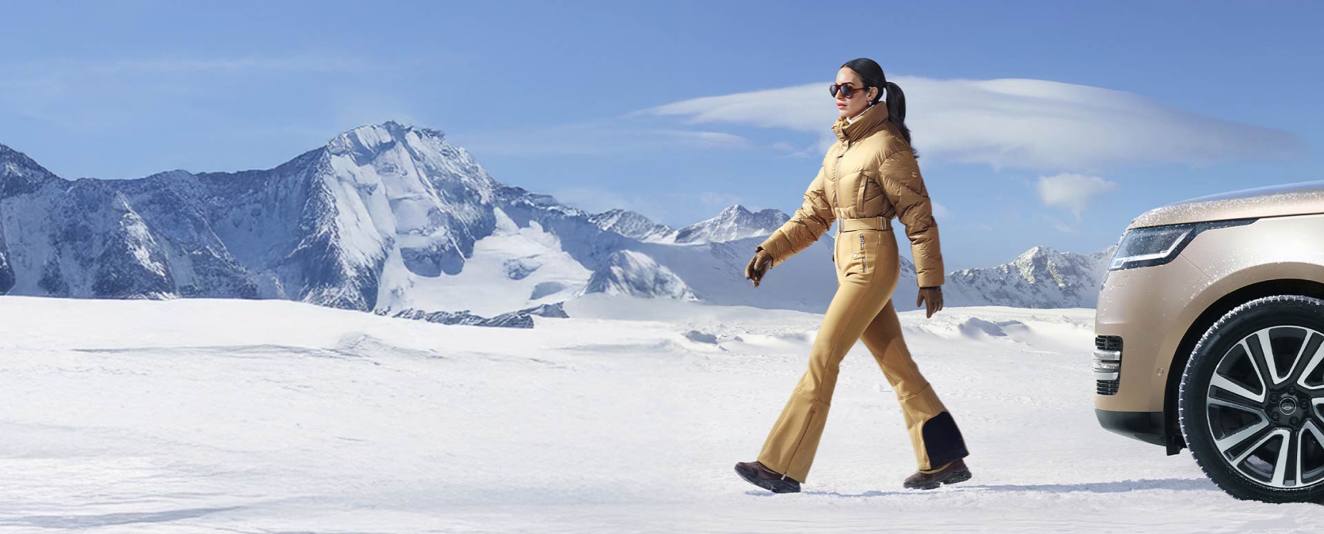 Woman Walking in Snow in Front of Range Rover