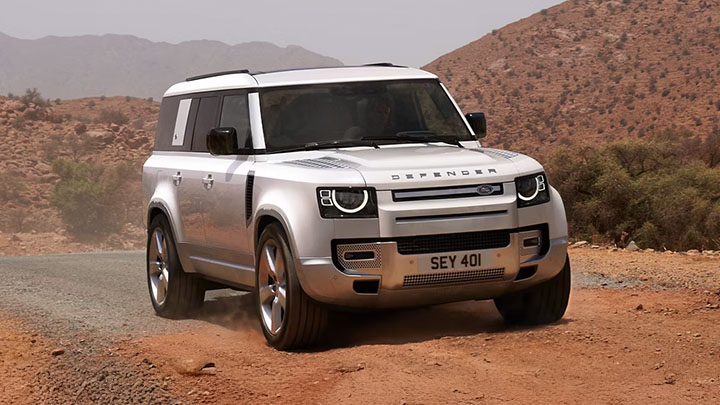 White Land Rover Defender Driving On Off-Road Dirt Track
