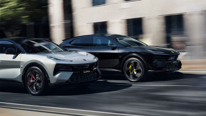 A grey and a black Lotus driving on the road