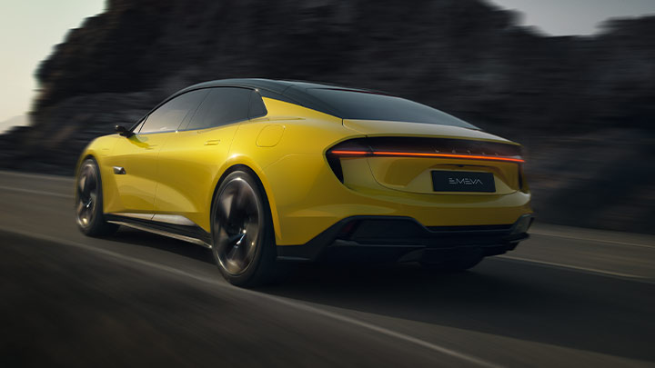 Rear quarter driving shot of a yellow Lotus Emeya