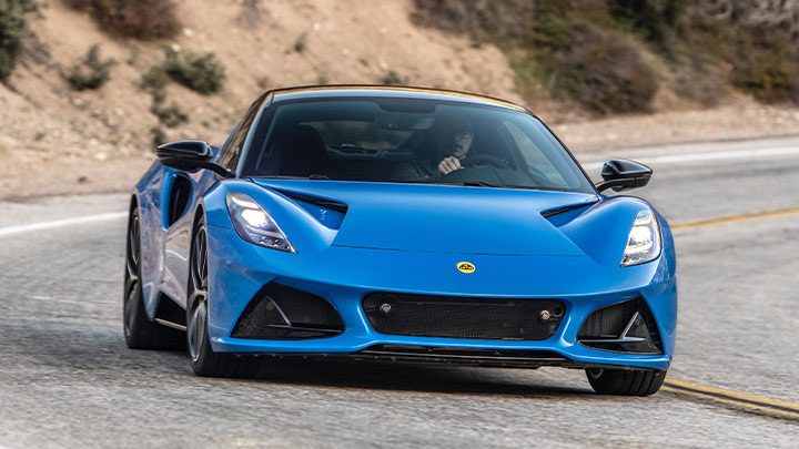 Driving shot of a blue Lotus Emira on a mountain road
