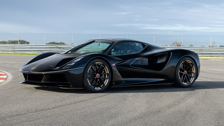 Stationary shot of a black Lotus Evija that's parked on track