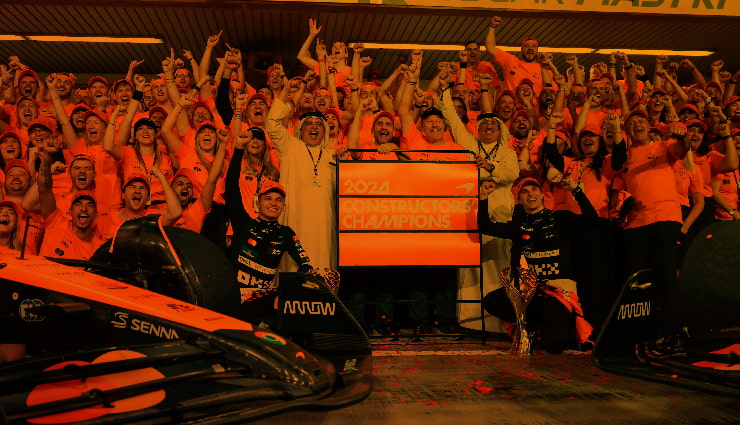 Group of people gathered around. The image has a strong orange filter.