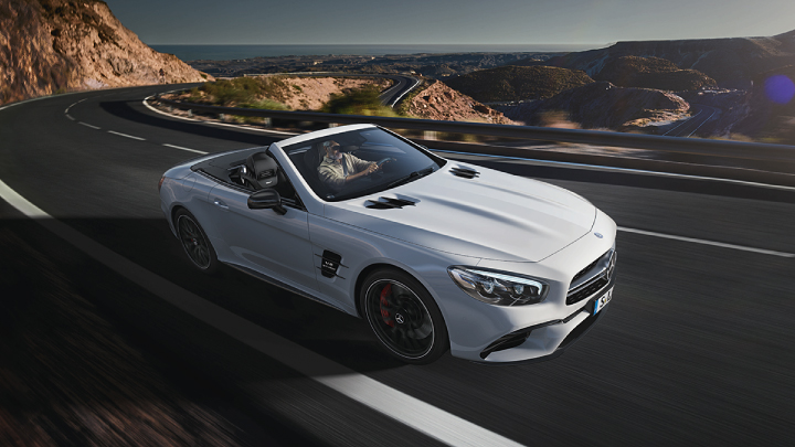 White Mercedes-Benz SL driving on the road.