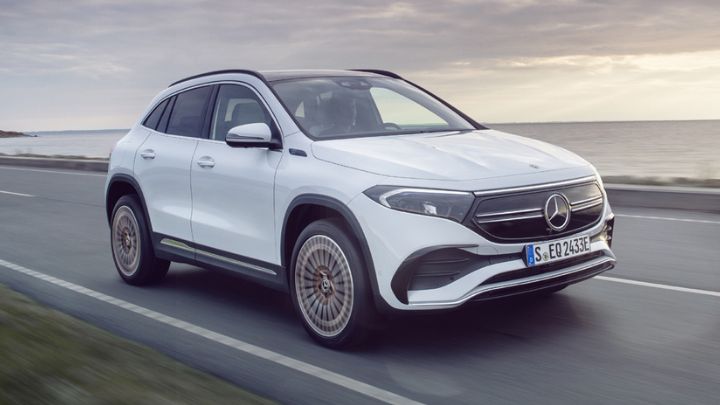 White Mercedes-Benz EQA driving by the ocean