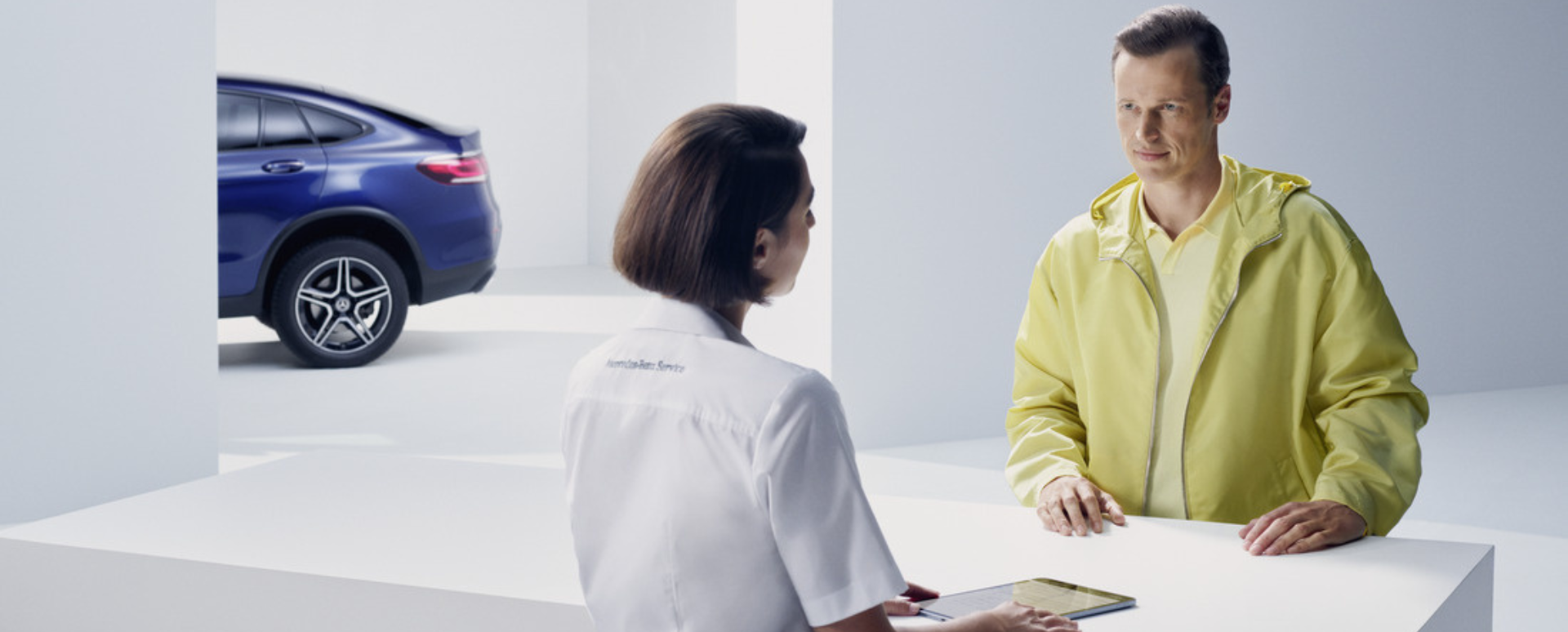 Woman Talking to Customer Over White Desk