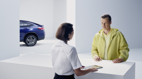 Woman Talking to Customer Over White Desk