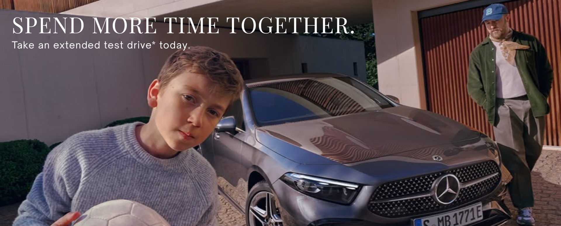 Father and Son Stood With a Silver Mercedes Vehicle