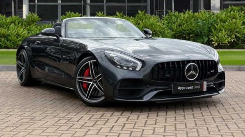 Black Mercedes-Benz AMG GT C parked in front of a dealership