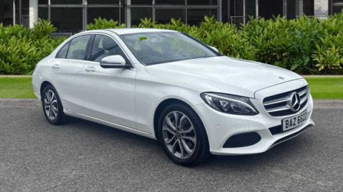 White Mercedes-Benz C-Class parked in front of a dealership