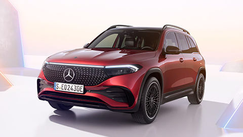 Red Mercedes-Benz EQB parked in front some rainbow coloured triangles