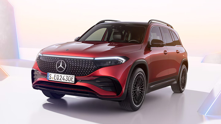 Red Mercedes-Benz EQB parked in front some rainbow coloured triangles