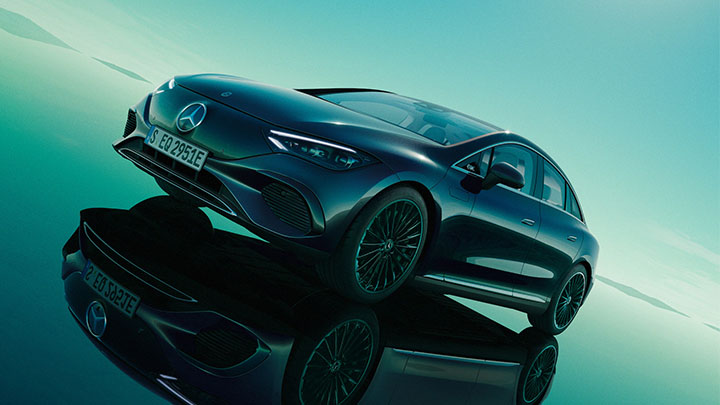Black Mercedes-Benz EQE driving on a green background