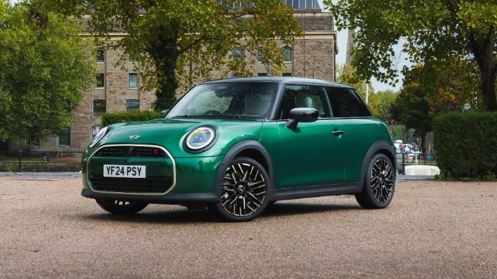 Green MINI parked across the road of a big brick building